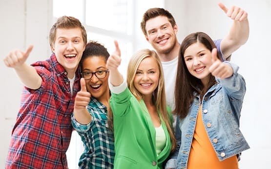 A group of students giving thumbs up to the camera